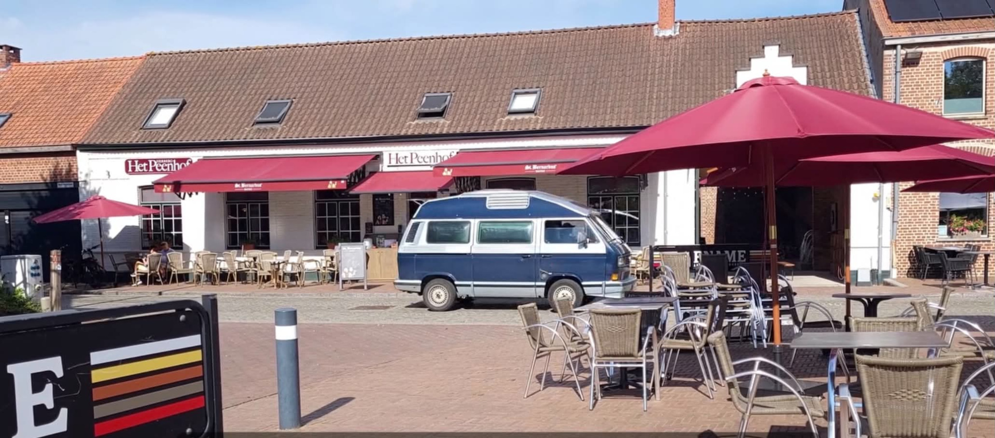Het terras van Het Peenhof met bordeauxrode parasols